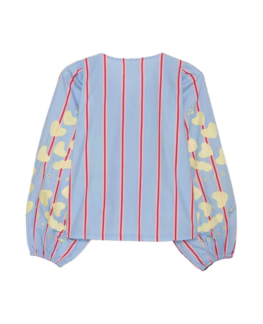 Light blue blouse with red stripes and yellow cloud patterns on a black background